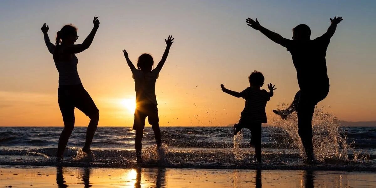 Family enjoying time together on the beach instead of cleaning